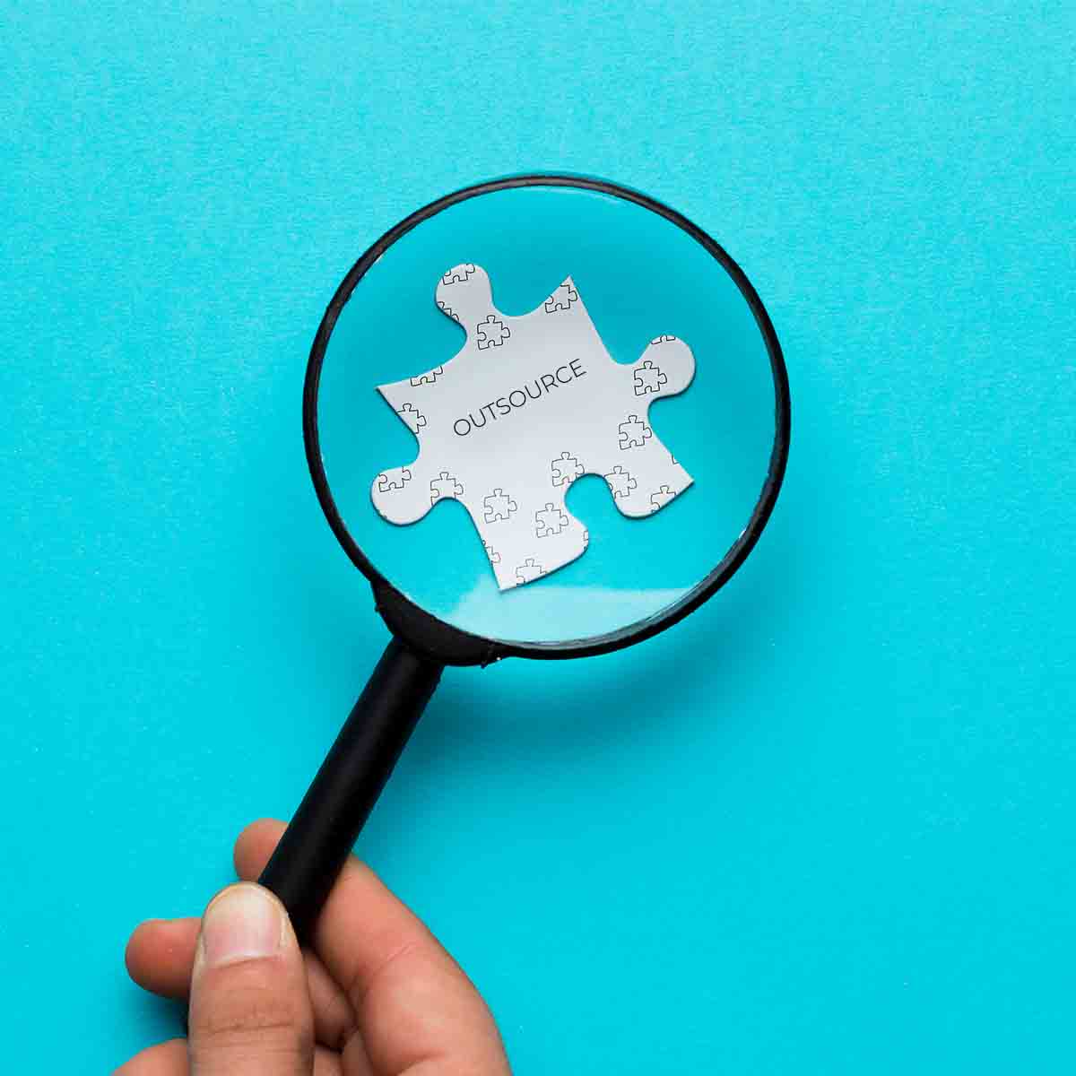 Magnifying Glass on a Puzzle Piece in How to Find the Best Outsourced Bookkeeping Company Sub banner by Magellan Solutions