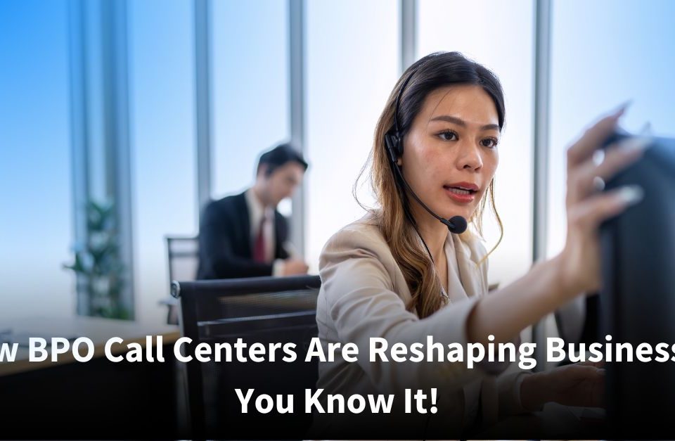 A female call center agent wearing a headset focuses on her computer screen as she assists a caller, while a colleague works in the background of a bright, modern office.